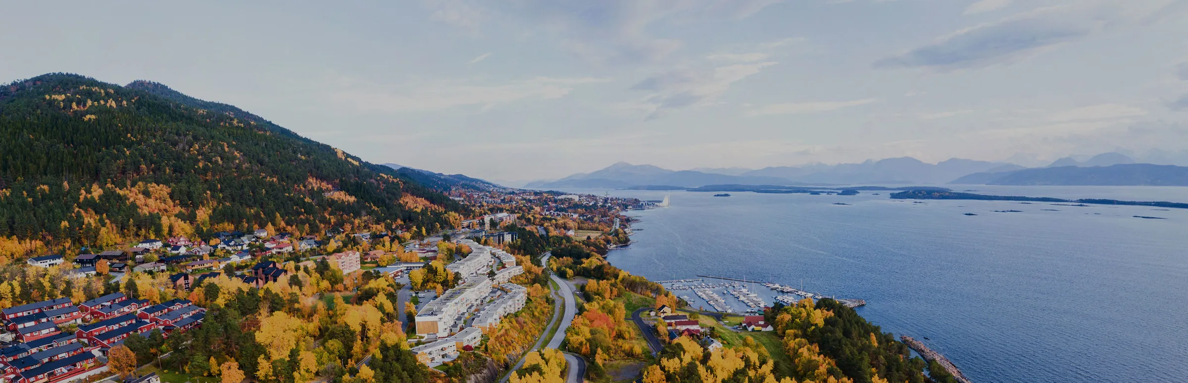 Molde sett fra lufta en høstdag, med byen, småbåthavna og fjorden